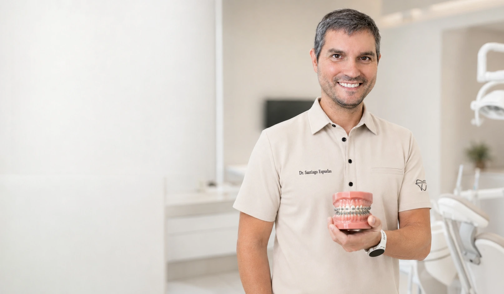 Brackets en Ibi - Dr. Santiago Espuelas El Dr. Santiago Espuelas, ortodoncista, sostiene un modelo dental con brackets metálicos en la clínica de Ibi